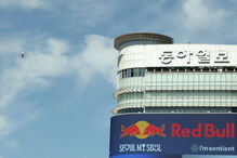 Homem faz slackline junto a edifício com anúncio da Red Bull em Seul