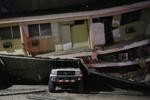 A vehicle lies crushed beneath a collapsed building after an earthquake struck Penonome, Panama, Friday, Oct. 9, 2026. (AP Photo/Aris