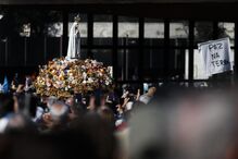 Pilgrims watch as the statue of Our Lady of Fátima