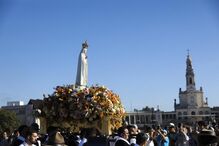 Pilgrims watch as the statue of Our Lady of Fátima