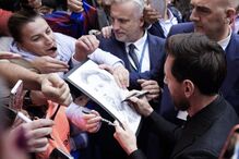 Argentine soccer player Lionel Messi signs autographs for fans upon