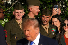 Members of the military look on after being greeted by President Donald Trump on the South Lawn of the White