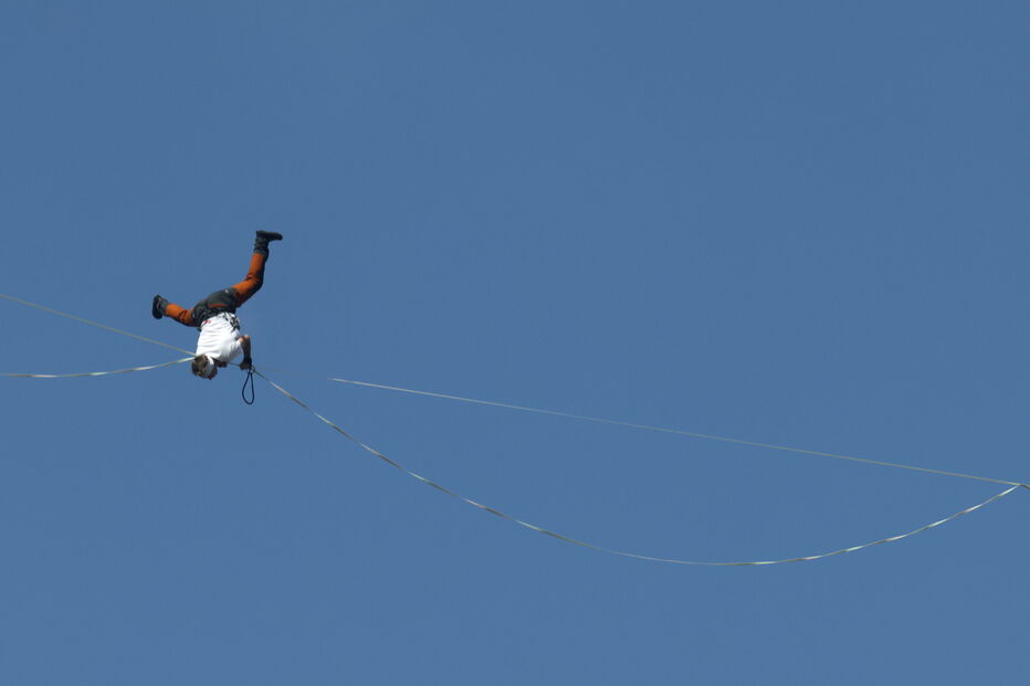 Um equilibrista em mortalha na linha, contra um céu azul