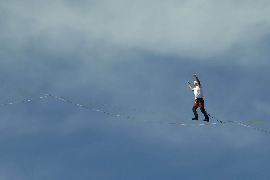 Homem em arame sobre o céu