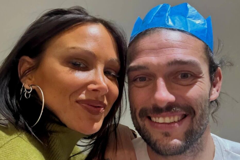 Um casal celebra com uma coroa festiva e um gorro de natal