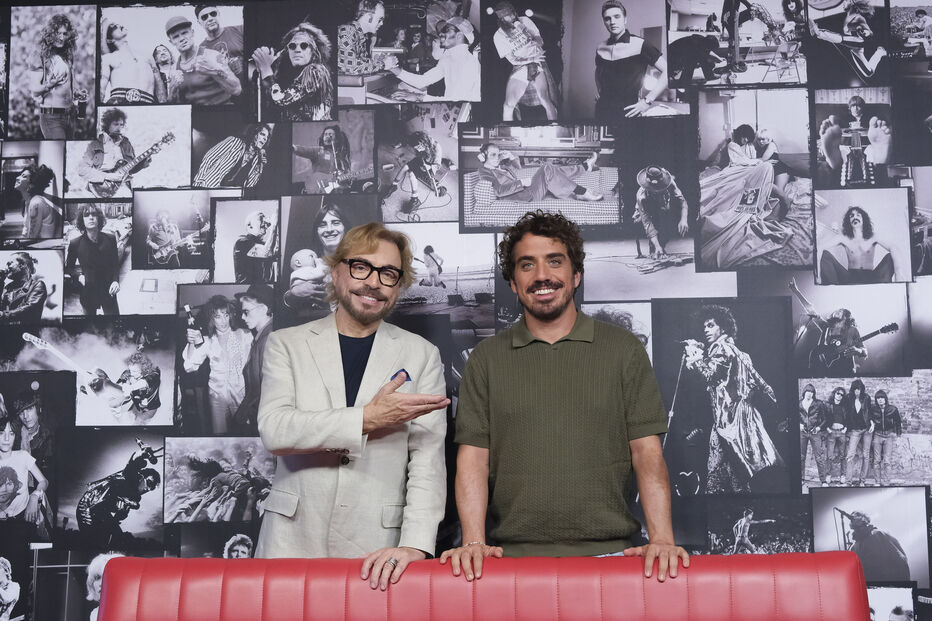 Diogo Martins e um convidado posam com imagens de artistas icónicos
