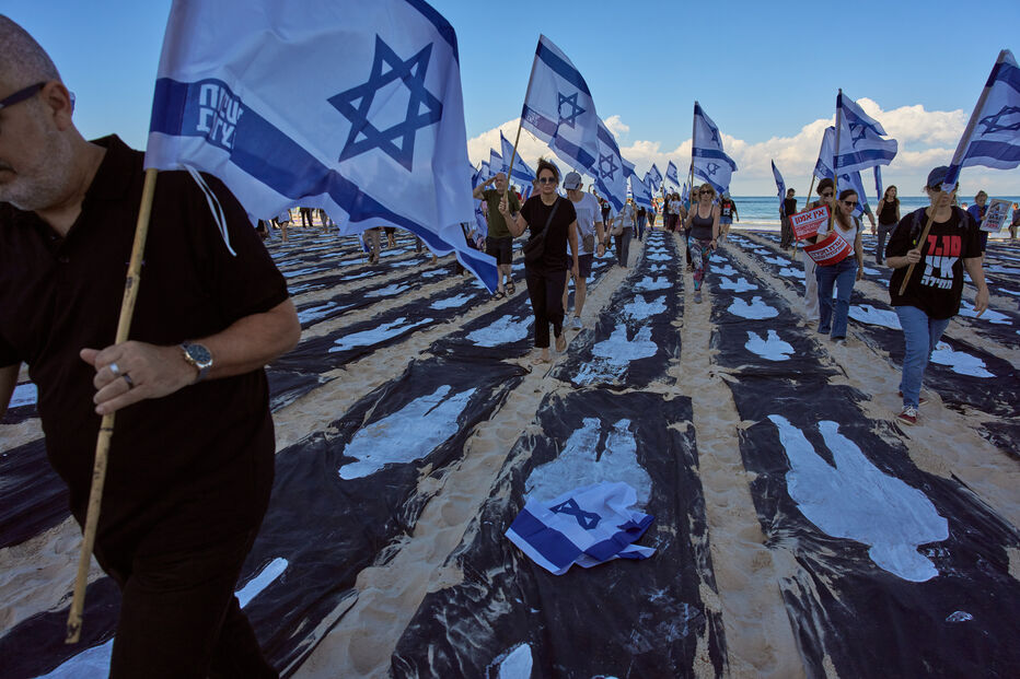 Manifestantes desfilam na praia com bandeiras de Israel