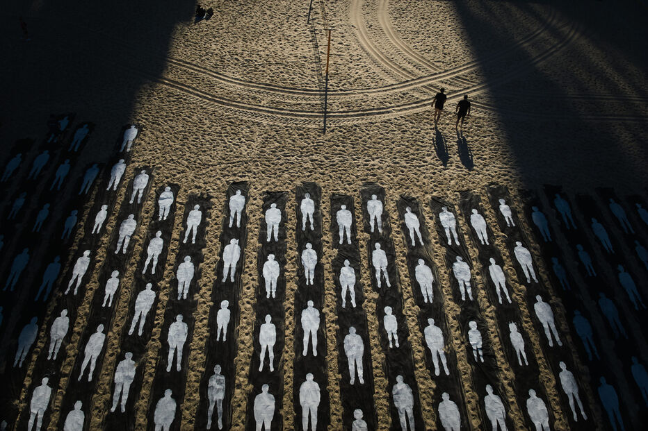 Figuras humanas em preto e branco numa praia, junto a duas pessoas