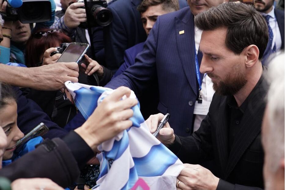Argentine soccer player Lionel Messi signs autographs for fans upon