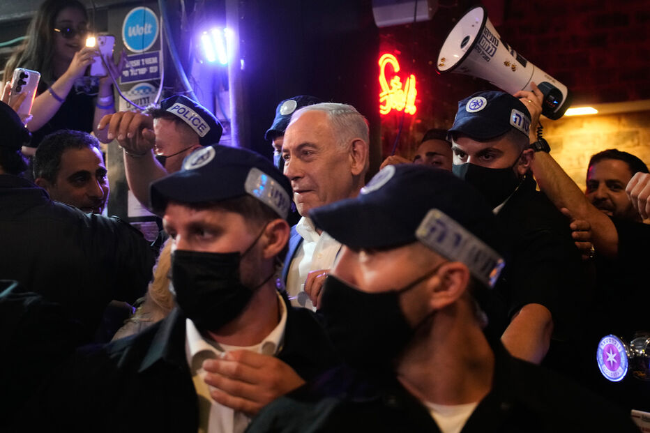 Benjamin Netanyahu, é acompanhado por agentes de segurança durante uma visita de campanha eleitoral ao Mercado Mahane Yehuda, em Jerusalém