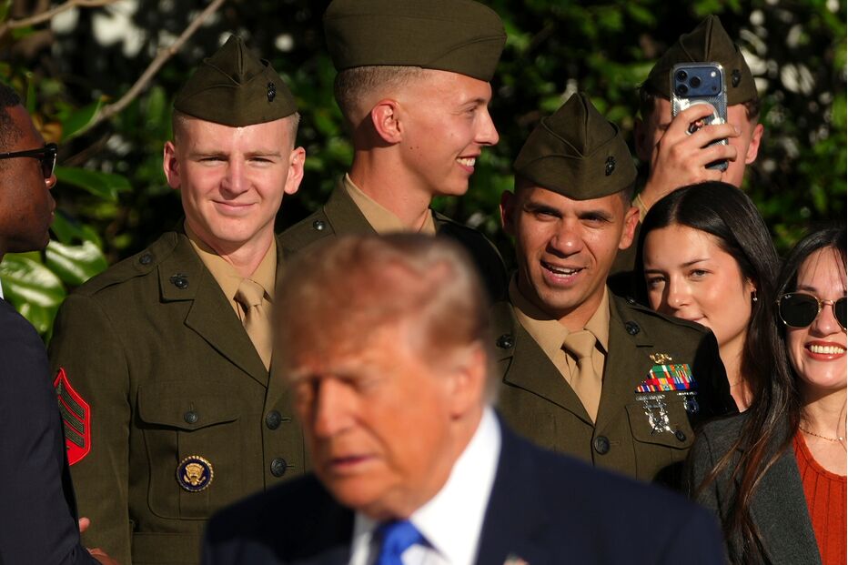 Members of the military look on after being greeted by President Donald Trump on the South Lawn of the White
